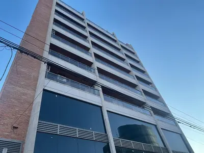 a tall brick building with a large window at Apart Ribera, Rio Cuarto in Río Cuarto