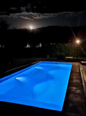 a blue pool is lit up at night at Altos de San Blas in San Javier