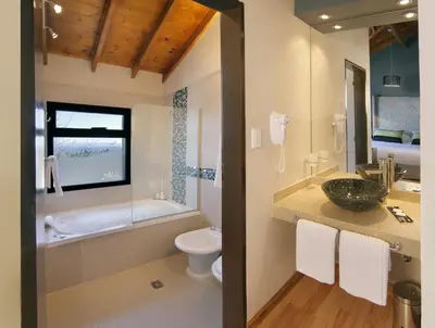 a bathroom with a sink and a tub and a toilet at Melodias Posada Boutique in Los Reartes