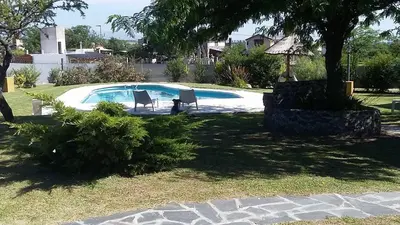 a pool with two chairs and a table in a yard at Melodias Posada Boutique in Los Reartes