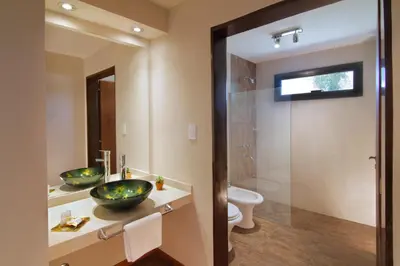 a bathroom with two sinks and a shower at Melodias Posada Boutique in Los Reartes