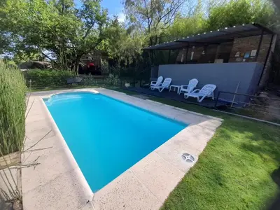 a swimming pool in the backyard of a house at PIEDRALAGO CABAÑAS Y TURISMO in Villa Carlos Paz