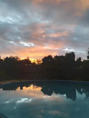 a pool of water with a sunset in the background at El Manantial in La Población