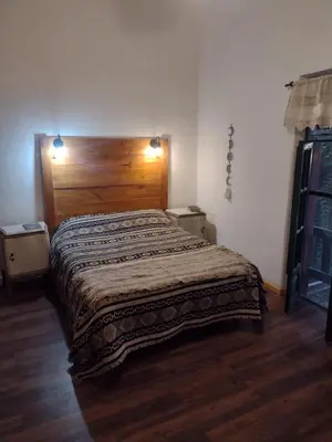 a bedroom with a large bed with a wooden headboard at El Manantial in La Población