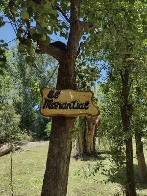 a sign for a marmalade sign on a tree at El Manantial in La Población