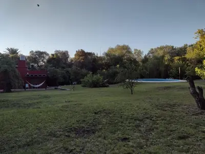 a large field with a red building and trees at El Manantial in La Población
