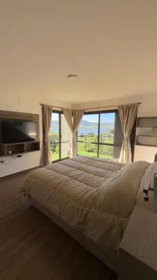 a bedroom with a large bed with a large window at AIRES DEL LAGO in Villa Carlos Paz