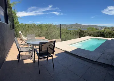 a patio with a table and chairs next to a swimming pool at AIRES DEL LAGO in Villa Carlos Paz