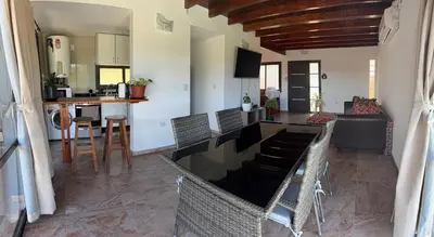a kitchen and living room with a table and chairs at AIRES DEL LAGO in Villa Carlos Paz