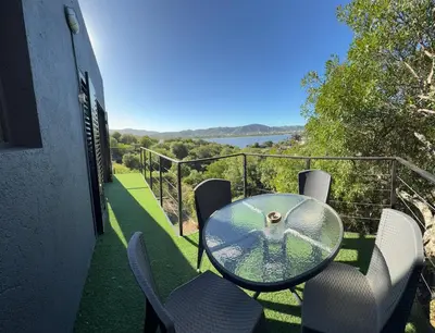 a glass table and chairs on the balcony of a house at AIRES DEL LAGO in Villa Carlos Paz