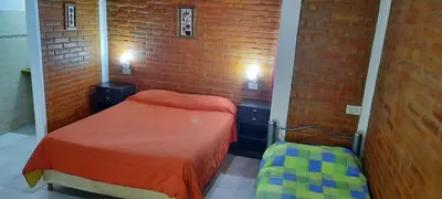 a small room with a bed and a brick wall at Aiken Cabañas in Villa Cura Brochero