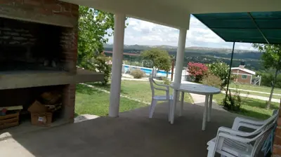a patio with a table and chairs and a fireplace at Aiken Cabañas in Villa Cura Brochero