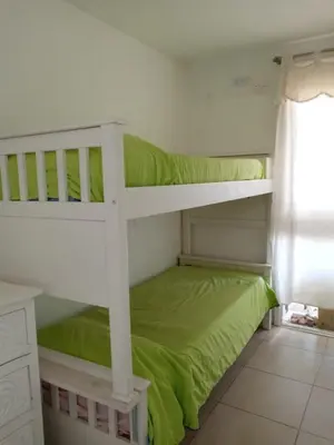 a bedroom with two bunk beds with green sheets at TERRAZAS DE LA COMARCA in La Cuesta