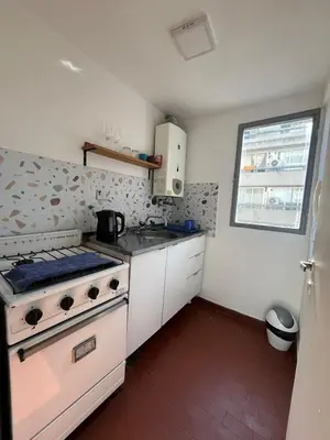 a small kitchen with a stove and a window at Chile 210, Nueva Cordoba in Cordoba