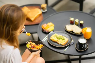 a woman eating food on a table with plates of food at Gardenia Select in San Javier