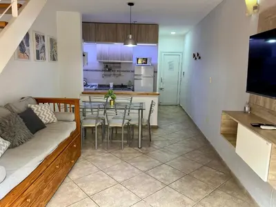 a living room and kitchen with a couch and a table at Depto 8 - Villa Carlos Paz in Villa Carlos Paz