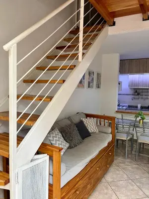 a couch under the stairs in a living room at Depto 8 - Villa Carlos Paz in Villa Carlos Paz