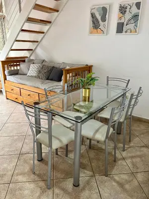 a glass dining room table with chairs and a couch at Depto 8 - Villa Carlos Paz in Villa Carlos Paz