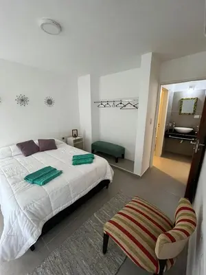 a bedroom with a bed and a bathroom with a sink at El canto de los pajaros in Villa Carlos Paz