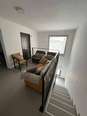 a living room with a couch and a staircase at El canto de los pajaros in Villa Carlos Paz