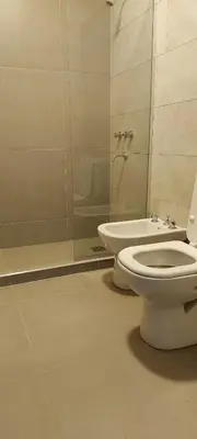 a bathroom with a toilet and a glass shower at El canto de los pajaros in Villa Carlos Paz