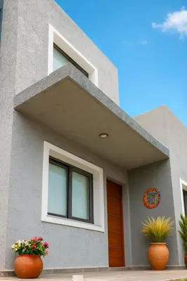 a house with two flower pots in front of it at El canto de los pajaros in Villa Carlos Paz