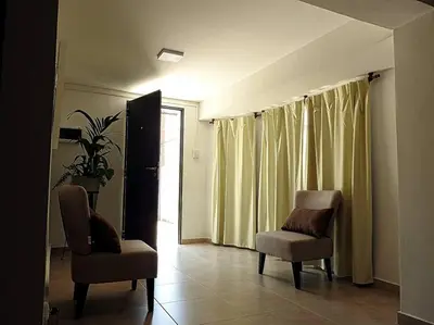 a living room with two chairs and a window at Departamento zona centrica en Villa Carlos Paz in Villa Carlos Paz