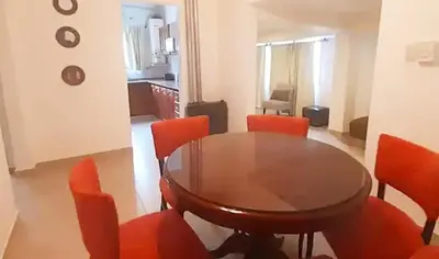 a dining room with a wooden table and red chairs at Departamento zona centrica en Villa Carlos Paz in Villa Carlos Paz