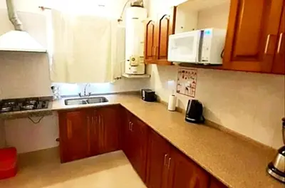 a kitchen with wooden cabinets and a counter top at Departamento zona centrica en Villa Carlos Paz in Villa Carlos Paz