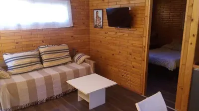 a small room with a bed and a small table at Cabañas El Druida in Villa General Belgrano