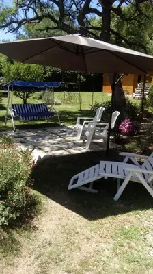 a group of lawn chairs and an umbrella at Cabañas El Druida in Villa General Belgrano