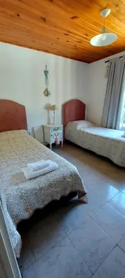 a bedroom with two beds and a wooden ceiling at Cabaña VGB. in Villa General Belgrano