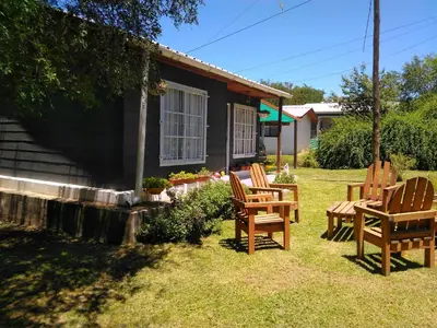 a group of chairs sitting outside of a house at Cabaña VGB. in Villa General Belgrano