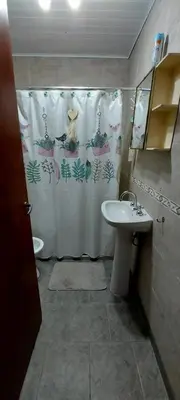 a bathroom with a shower curtain and a sink at Cabaña VGB. in Villa General Belgrano