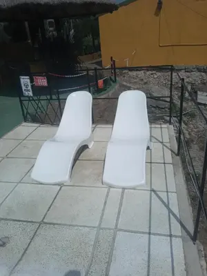 two white benches sitting on top of a sidewalk at Casa de alquiler 2 in Tanti