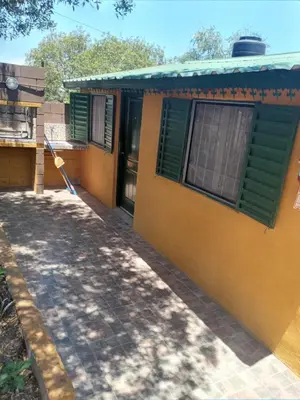 a yellow house with green shutters and a driveway at Casa de alquiler 2 in Tanti