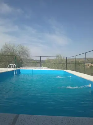 a large blue swimming pool with a fence around it at Casa de alquiler 2 in Tanti