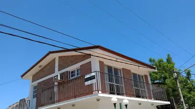 a building with a balcony on top of it at Departamento Centro Calamuchita in Santa Rosa de Calamuchita