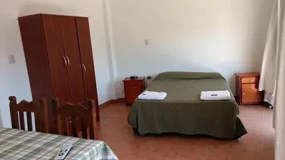 a bedroom with a bed and a dresser with towels at Departamento Centro Calamuchita in Santa Rosa de Calamuchita