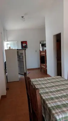 a room with a table and chairs and a kitchen at Departamento Centro Calamuchita in Santa Rosa de Calamuchita