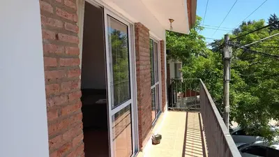 a balcony with sliding glass doors on a house at Departamento Centro Calamuchita in Santa Rosa de Calamuchita