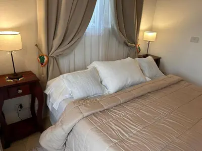a bed with white sheets and pillows in a bedroom at Sierras VGB Bertone in Villa General Belgrano