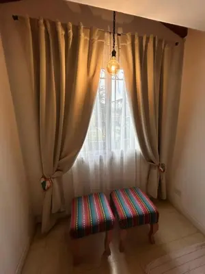 a bench in front of a window with curtains at Sierras VGB Bertone in Villa General Belgrano