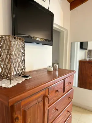 a wooden dresser with a television on top of it at Sierras VGB Bertone in Villa General Belgrano
