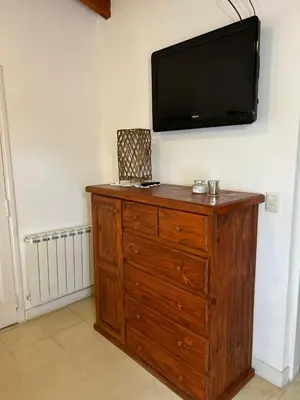 a wooden dresser with a flat screen tv on a wall at Sierras VGB Bertone in Villa General Belgrano