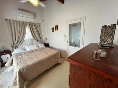 a bedroom with a bed and a dresser and a window at Sierras VGB Bertone in Villa General Belgrano