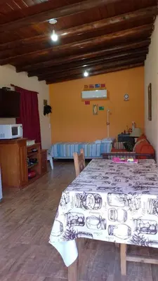 a living room with a table and a bedroom at Valle de Fatima in Villa de Las Rosas