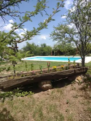 a wooden bench filled with flowers next to a pool at Valle de Fatima in Villa de Las Rosas