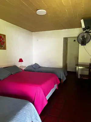 two beds in a room with a red blanket at Sauce Viejo in Mina Clavero