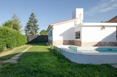 a white house with a pool in the yard at Casa en Villa Carlos Paz con Pileta , Quincho y Jardín a Pasos del Centro in Villa Carlos Paz